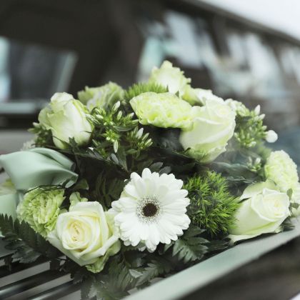 Weißes Trauergesteck mit Rosen und Gerbera