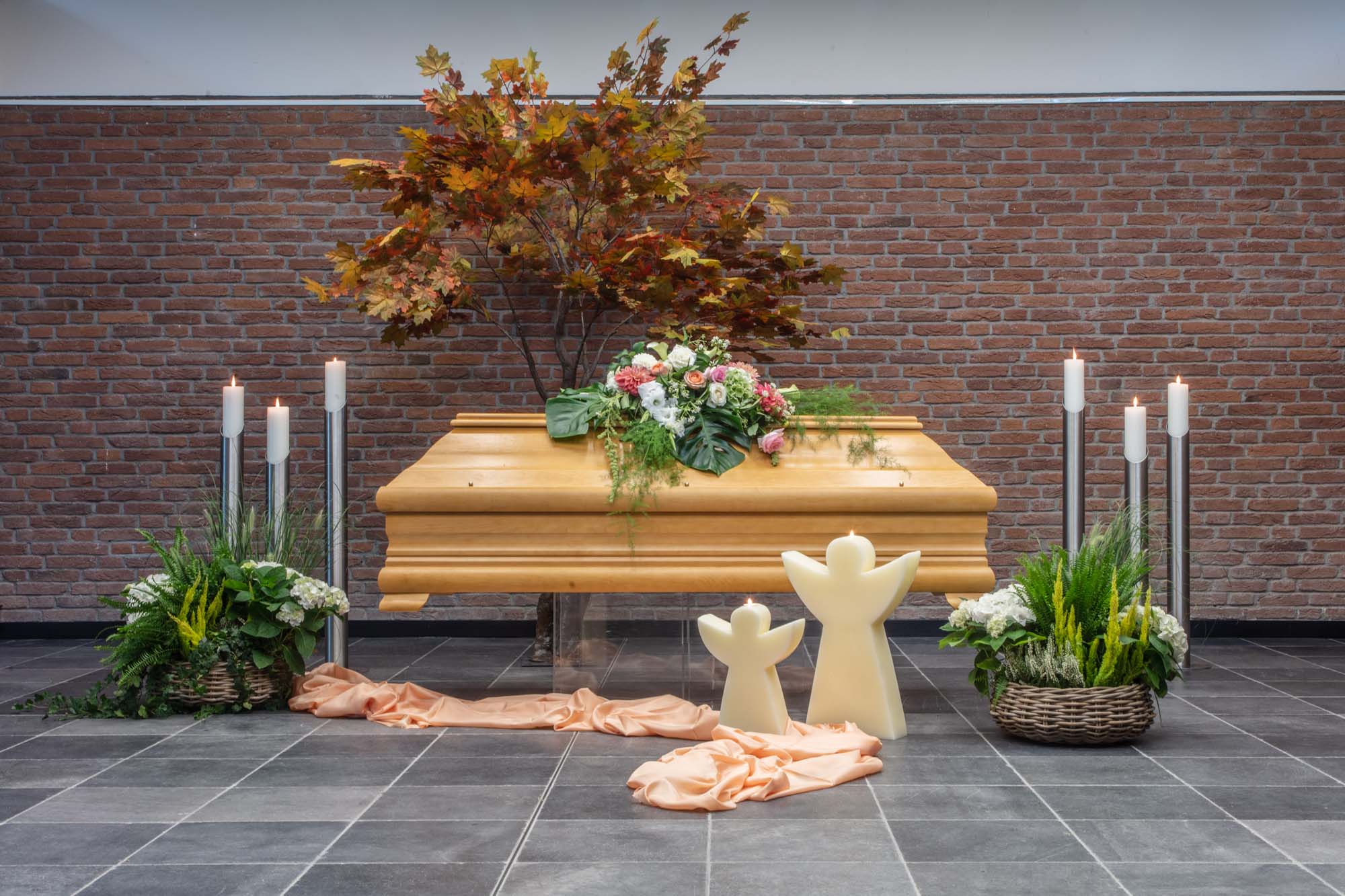 Sarg mit herbstlichem Blütenschmuck und Engelsfiguren