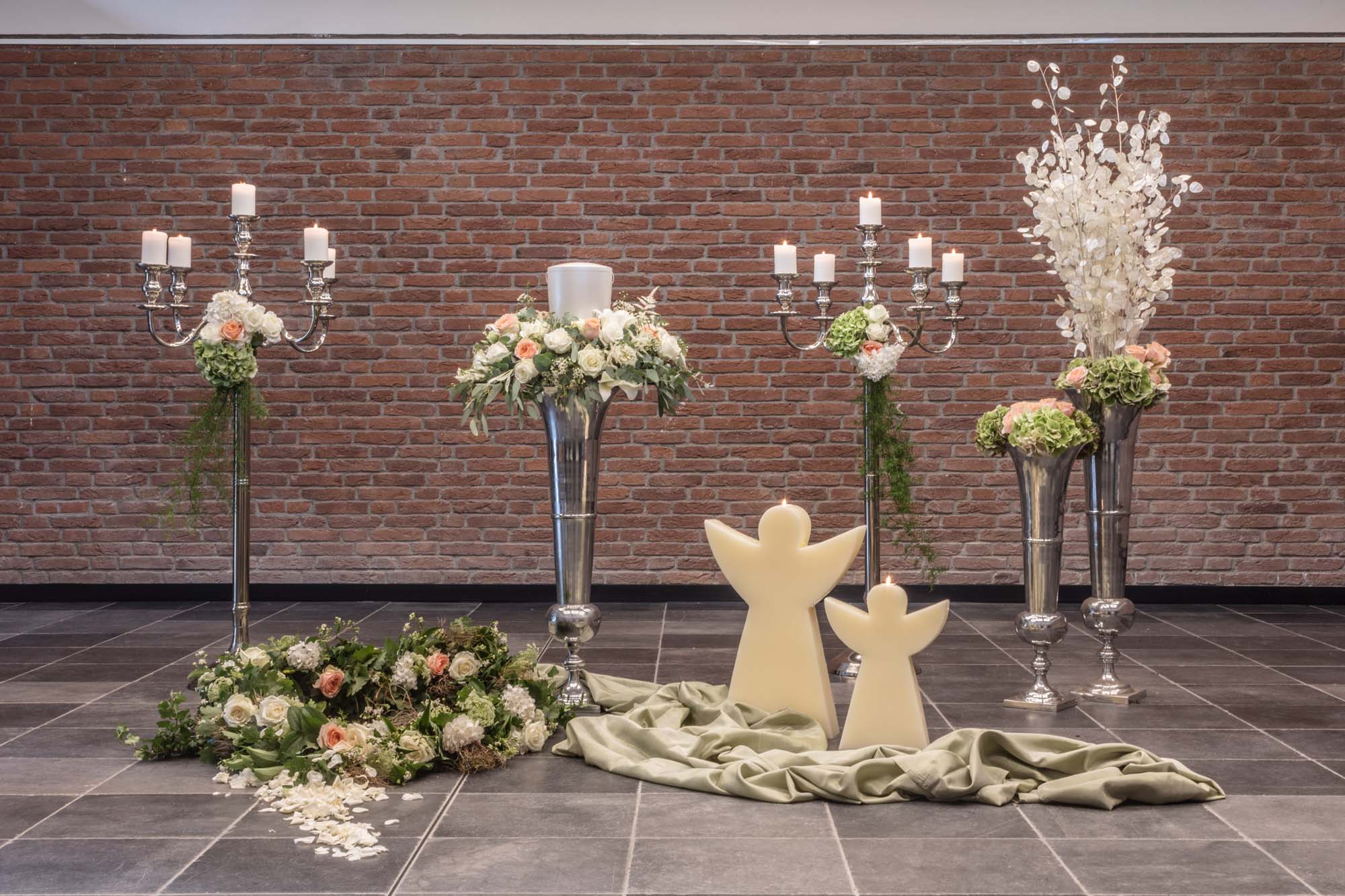 Silberne Kerzenleuchter, Engelsfiguren und Blumen