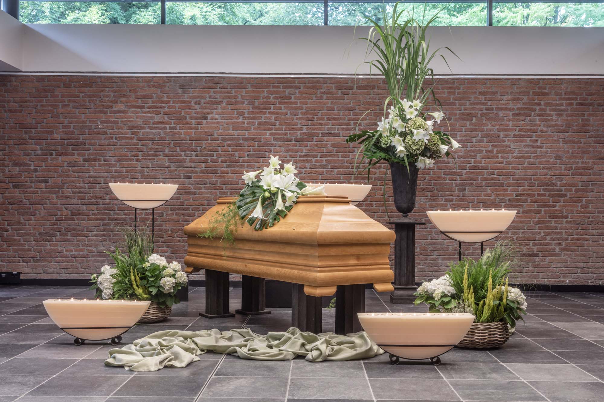 Sarg mit weißen Orchideen im lichtdurchfluteten Raum